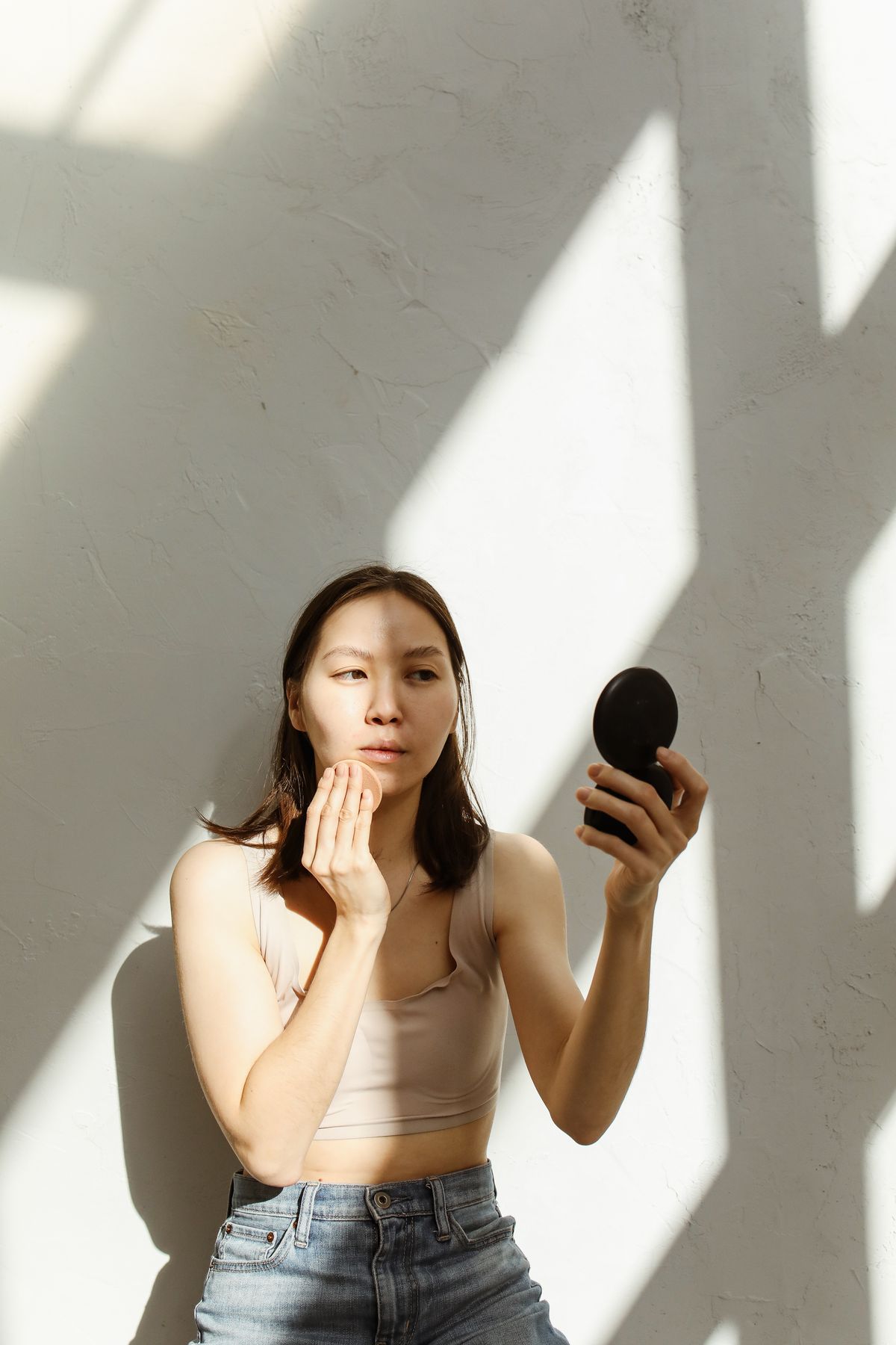 Model applying a cushion compact, one of the signature K-beauty product formats