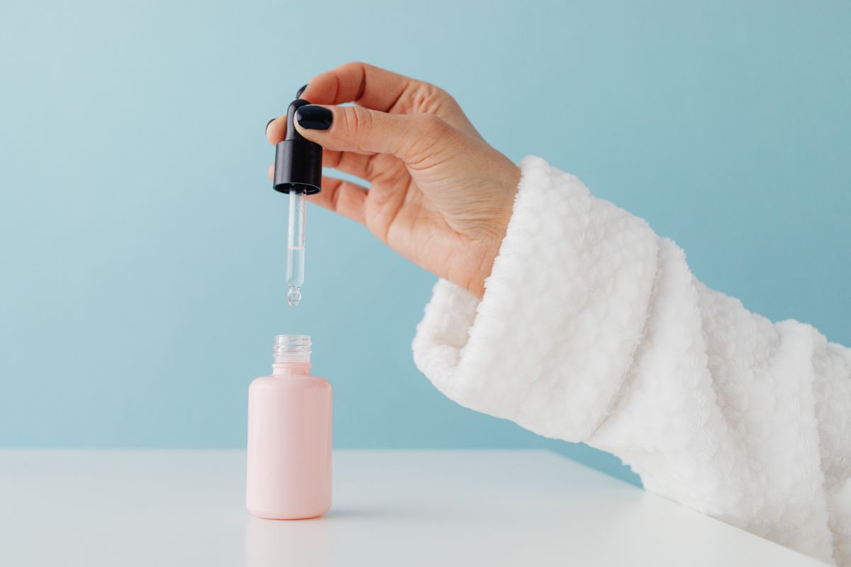 Hand holding a dropper with hyaluronic acid serum