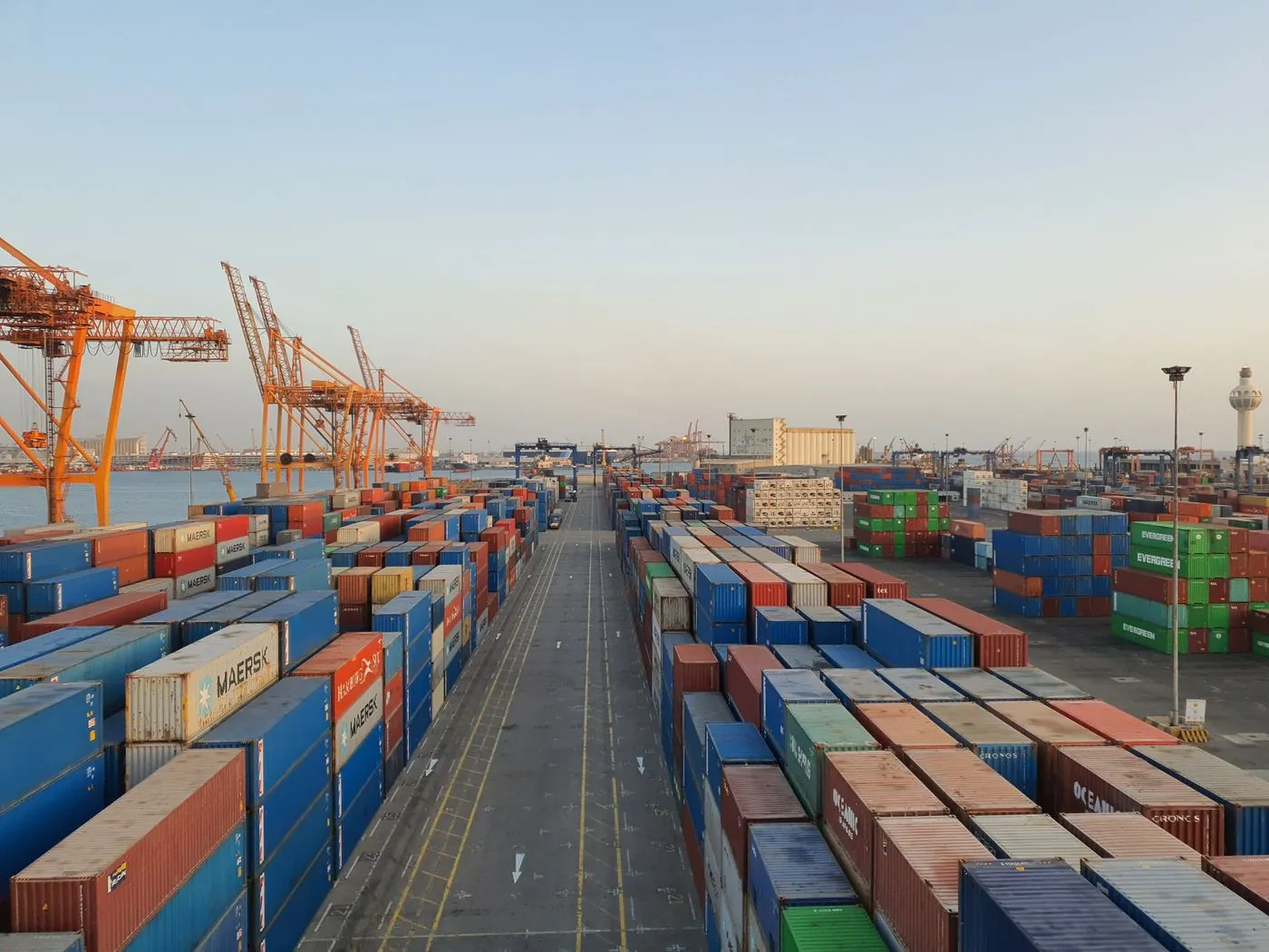 Shipping containers and cranes at a cargo port at sunrise