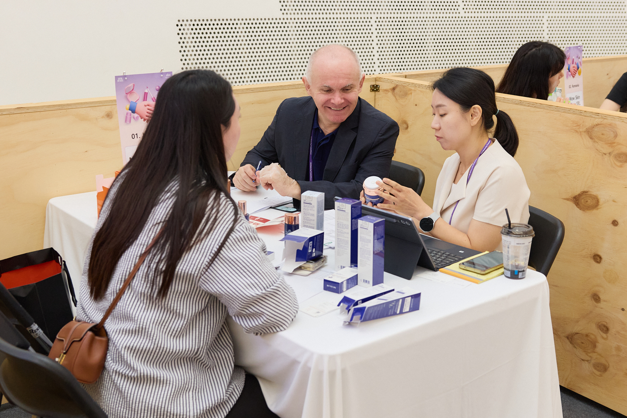 Overseas buyer reviewing Korean skincare samples in a one-on-one export consultation at Seoul Beauty Week 2026