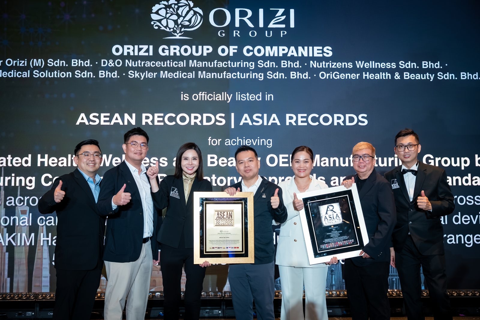 The ORIZI Group team on stage with both certificates: ASEAN Records and ASIA Records, 20 October 2026.